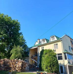 une maison avec une pile de bûches devant elle dans l'établissement Inn Sport, à Tchernivtsi