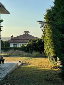 een bankje in een tuin met een huis op de achtergrond bij A Scenic villa near Airport in Buyukcekmece