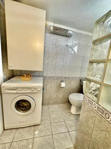ein Badezimmer mit einer Waschmaschine und einem WC in der Unterkunft Shell-paralia ofriniou in Ofrynio
