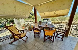 a patio with a table and chairs on a balcony at Shell-paralia ofriniou in Ofrínion