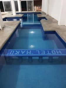 - une piscine avec des carreaux bleus dans un bâtiment dans l'établissement Hotel MARU Pool & Events, à Chachalacas