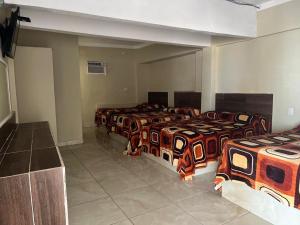eine Gruppe von 4 Betten in einem Zimmer in der Unterkunft Hotel MARU Pool & Events in Chachalacas