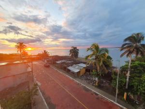 Elle offre une vue sur une rue bordée de palmiers et l'océan. dans l'établissement Hotel MARU Pool & Events, à Chachalacas