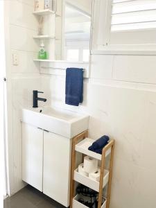 een witte badkamer met een wastafel en een spiegel bij Bay Breeze Cottage in Encounter Bay