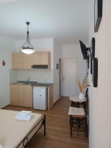 eine Küche mit einem Bett und einem Tisch in einem Zimmer in der Unterkunft Pension Ilias - Chora Amorgos in Amorgós