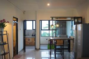 Una cocina con refrigerador y una mesa con sillas. en Cozy Haven with Jacuzzi, Rooftop, en Bandung