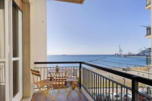 a balcony with a table and chairs and a view of the beach at Riva Mare 2 in Vado Ligure