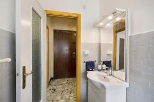 a white bathroom with a sink and a mirror at Riva Mare 2 in Vado Ligure +12 photos