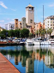 uma marina com barcos na água e uma torre do relógio em b&b bellavista em Savona