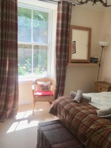 a bedroom with a bed and a window and a chair at Caledonian - Charming Central 1 Bed Flat in Edinburgh