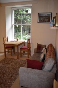 a living room with a couch and a table at Caledonian - Charming Central 1 Bed Flat in Edinburgh