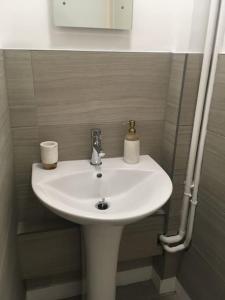 - un lavabo blanc dans une petite salle de bains dans l'établissement Caledonian - Charming Central 1 Bed Flat, à Édimbourg