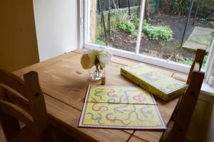 une table avec un vase de fleurs et deux livres dans l'établissement Caledonian - Charming Central 1 Bed Flat, à Édimbourg