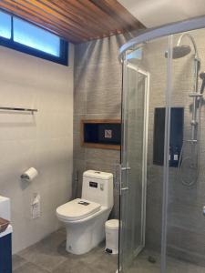 uma casa de banho com um WC e uma cabina de duche em vidro. em Maesa Greenery Hill SHA em Mae Rim