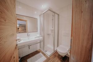 ein Bad mit einer Dusche, einem Waschbecken und einem WC in der Unterkunft Frühstückspension Friedheim in Filzmoos