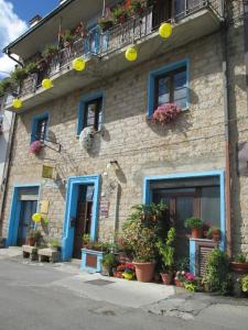 um edifício com portas e janelas azuis e vasos de plantas em Antichi Sapori da Speranza em Gavoi