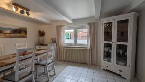 a kitchen with a table and chairs and a window at Fischerhaus Lemkenhafen in Lemkenhafen auf Fehmarn