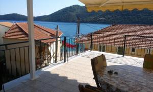 a balcony with a table and a view of the water at Porto Poros in Mikros Gialos