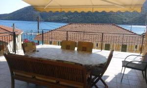 a table on a balcony with a view of a house at Porto Poros in Mikros Gialos