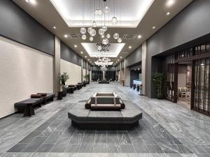 a lobby of a building with couches and a chandelier at Hotel Route Inn Grand Chichibu in Chichibu
