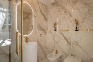 bagno con servizi igienici, lavandino e specchio di Maison Mirò with private parking a Lucca