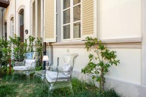 duas cadeiras e uma mesa em frente a uma casa em Maison Mirò with private parking em Lucca