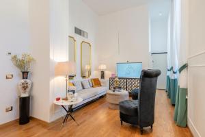uma sala de estar com um sofá e uma cadeira em Maison Mirò with private parking em Lucca