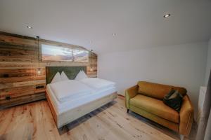 ein Schlafzimmer mit einem Bett und einem Stuhl in der Unterkunft Frühstückspension Friedheim in Filzmoos