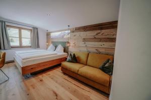 ein Hotelzimmer mit einem Bett und einem Sofa in der Unterkunft Frühstückspension Friedheim in Filzmoos