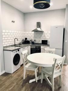 梅里達的住宿－Apartamentos Élite - Art Collection - Vincent，厨房配有白色的桌椅和水槽