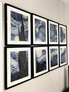 eine Gruppe von vier Gemälden, die an einer Wand hängen in der Unterkunft Apartamentos Élite - Art Collection - Vincent in Merida