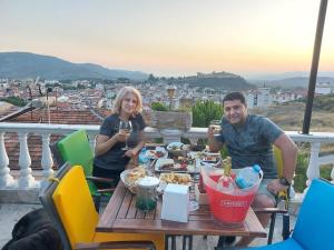 a man and woman sitting at a table with wine glasses at Villa Manzara in Selcuk