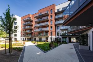 an apartment building with a walkway in front of it at Hollywood Jacuzzi Suite by Downtown Apartments in Gdańsk