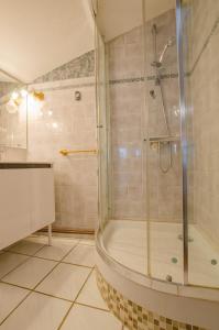 uma casa de banho com um chuveiro e uma banheira em Le gite de la faiencerie 
