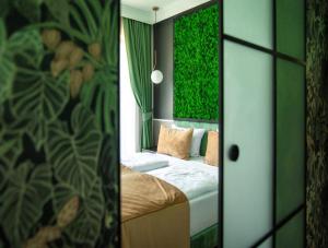 sypialnia z łóżkiem i zieloną ścianą w obiekcie Aparthotel Green Concrete - nowy, ekologiczny hotel w Świnoujściu w Świnoujściu
