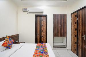 ein Schlafzimmer mit einem Bett und einigen Holzschränken in der Unterkunft FabHotel 17 Suites in Noida