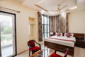 ein Hotelzimmer mit einem Bett und einem Fenster in der Unterkunft FabHotel 17 Suites in Noida