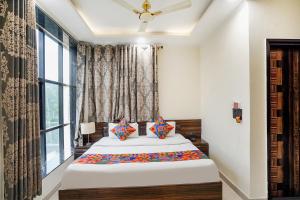 1 Schlafzimmer mit 2 Betten und einem Fenster in der Unterkunft FabHotel 17 Suites in Noida