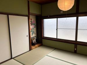 an empty room with two windows and a door at 吉野長屋 in Yoshino