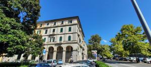 un grande edificio con auto parcheggiate di fronte di Ferry House a La Spezia