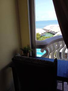 uma vista para o oceano a partir da janela de um quarto de hotel em Cozy Seaview Glory Beach Resort ANC em Porto Dickson