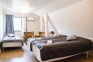 a bedroom with two beds and a window at Bed & Breakfast Restaurang Sybarit in Houtskari