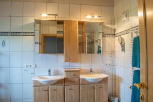 a bathroom with two sinks and a mirror at Weinzeit Chalet & Appartements in Königsleiten