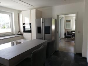 a kitchen with a table and a stainless steel refrigerator at Ferienhaus Johanna in Spitz