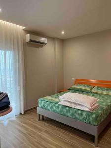 een slaapkamer met een bed en een raam bij SKetch Apartments in Durrës