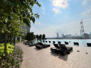 a row of lounge chairs next to a body of water at M Vertica KL Residence in Kuala Lumpur