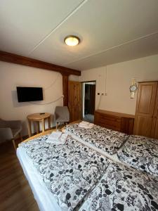 a bedroom with a large bed with a black and white blanket at Penzion Trampska Bouda in Abertamy