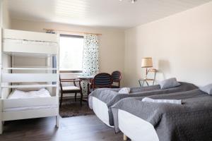 a bedroom with two beds and a table and a window at Bed & Breakfast Restaurang Sybarit in Houtskari