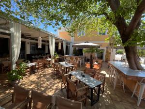 un patio extérieur avec des tables, des chaises et un arbre dans l'établissement GIARDINO High living suites, à Dráma