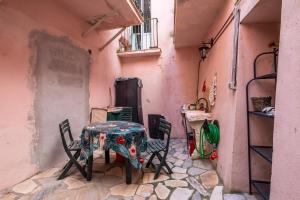 a table and chairs in a room with a pink wall at Casa Vacanze Santa Clara in Orbetello